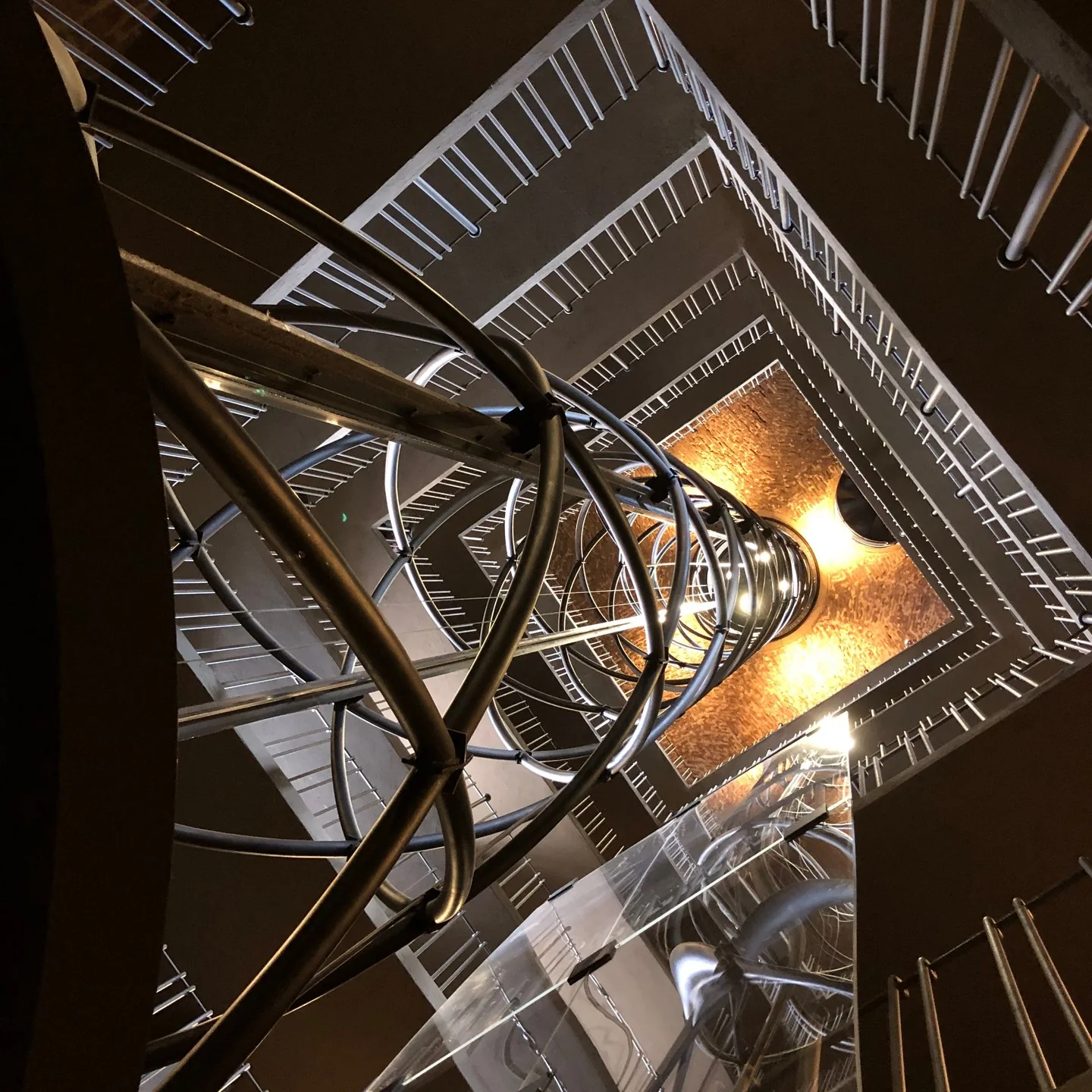 A view looking up a modern open elevator shaft.