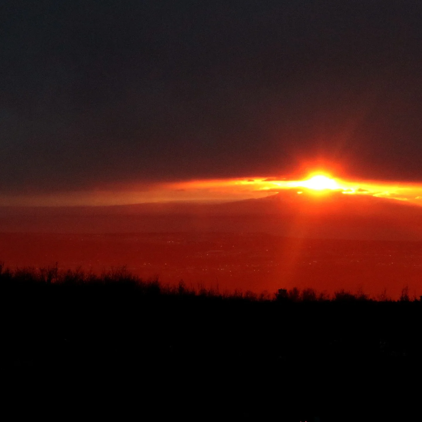 The sun setting behind mountains west of Anchorage. The positioning and lens flare create an effect reminiscent of the Eye of Sauron from the Lord of the Rings movies.