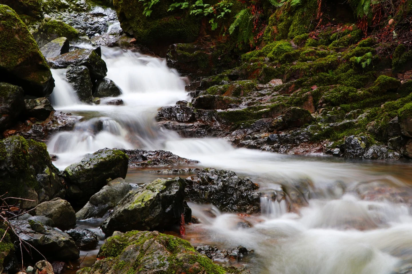 A long exposure picture of a small waterfall and stream.