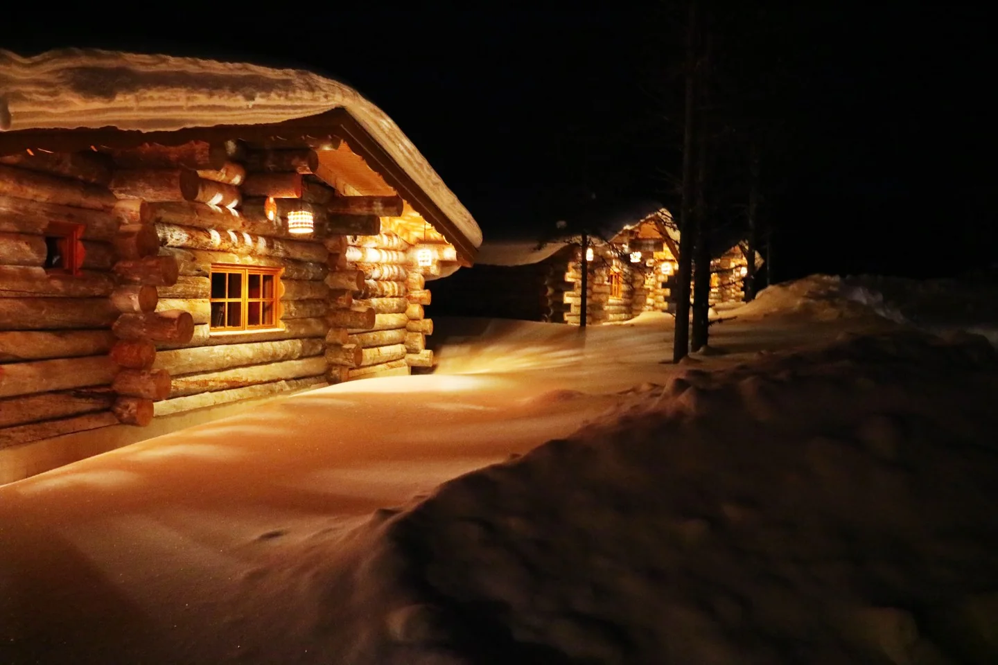 Cabins in the snow at night.