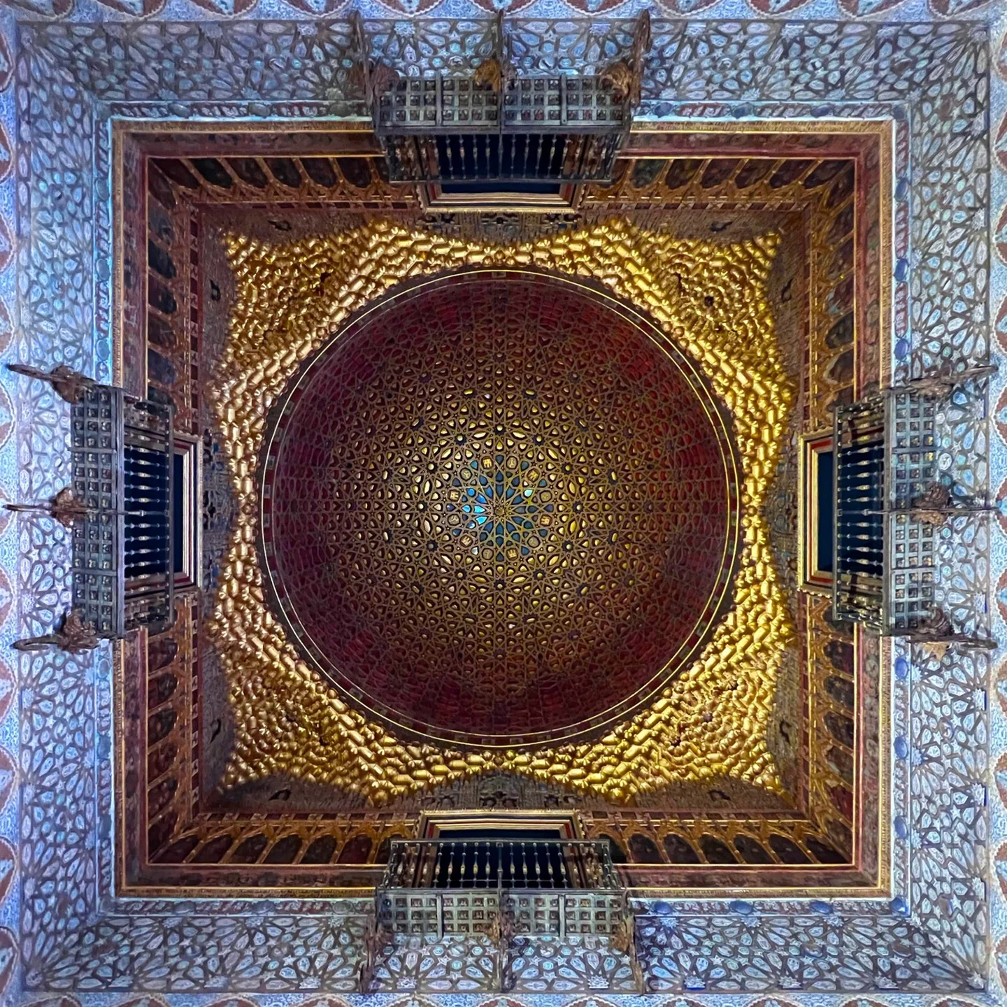 An edited photograph looking straight up at the ceiling of the Hall of Ambassadors in the Alcázar of Seville.